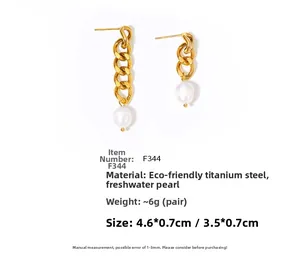 Detail view of gold titanium steel earrings with asymmetrical chain and freshwater pearls