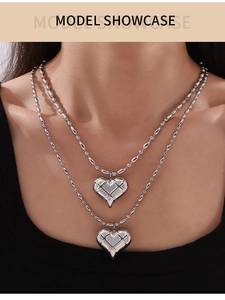 Close-up of double-layer bead chain necklace with quilted hollow heart pendants