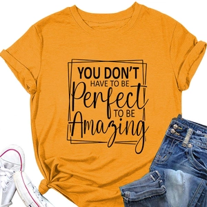 Close-up of the quote print on a loose orange crewneck t-shirt with flat lay styling