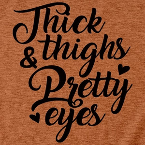 Close-up of Thick & Thighs Pretty Eyes lettering on a caramel cotton T-shirt