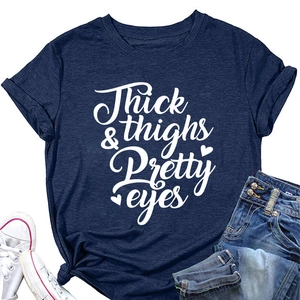 Flat lay of navy blue crewneck T-shirt with Thick & thighs Pretty eyes white print