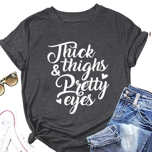 Flat lay of charcoal grey cotton t-shirt with Thick Thighs Pretty Eyes white text