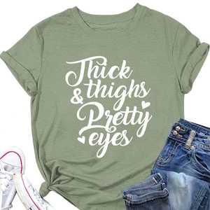 Detail of sage green cotton t-shirt featuring Thick thighs & Pretty eyes printed text