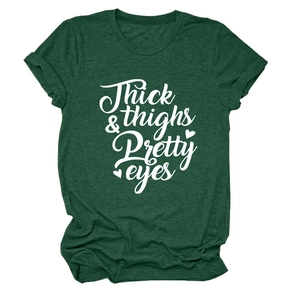 Detail of Thick & Thighs Pretty Eyes lettering on a dark green cotton blend t-shirt