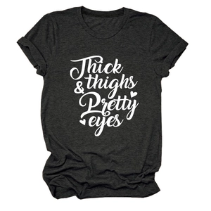 Close-up of Thick & Thighs Pretty Eyes white typography on charcoal grey cotton t-shirt