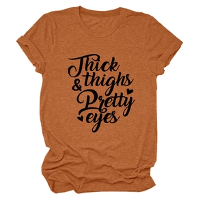 Close-up of rust orange cotton T-shirt featuring Thick & Thighs Pretty Eyes lettering