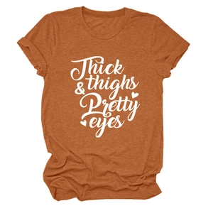 Detail of caramel t-shirt featuring Thick & Thighs Pretty Eyes letter print and heart graphic