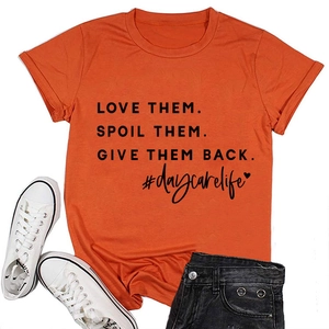 Detailed view of orange cotton t-shirt with black printed slogan on flat lay display