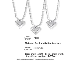 Close-up of heart pendants with quilted texture on silver titanium steel bead chains