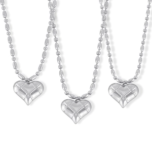 Three quilted heart pendant necklaces with modern beaded steel chains on white background