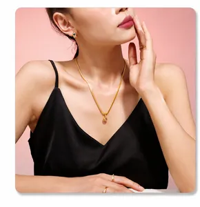 Nahaufnahme einer 18k vergoldeten geometrischen Kette und Zirkonia-Ohrringen an einem Modell