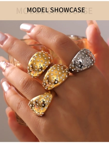 Close-up of model wearing wide geometric rings with sparkling inlaid zircon stones