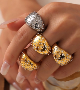 Macro shot of 18k gold and silver geometric wide rings set with shimmering cubic zirconia