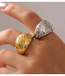 Close-up of wide dome rings in gold and silver with shimmering pavé set crystals