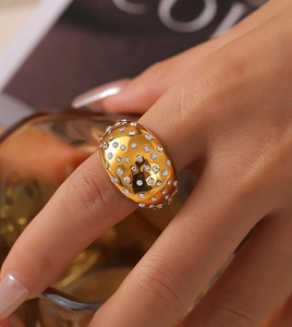 Detailed view of a wide 18k gold-plated geometric ring encrusted with white crystals