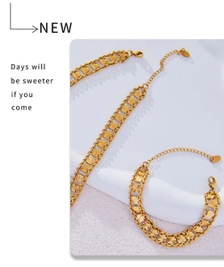Detailed macro of gold plated geometric chain jewelry set with lobster clasp and logo charm