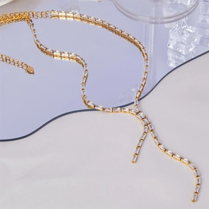 Elegant gold-plated tennis necklace with rectangular zircons on reflective background