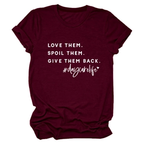 Detailed close-up of burgundy crew neck t-shirt featuring white daycare life slogan print