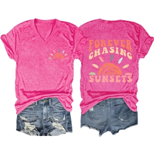 Detail of pink V-neck T-shirt back with Forever Chasing Sunsets graphic and denim shorts