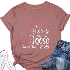 Flat lay of pink Sisters On The Loose T-shirt with denim jeans and white sneakers