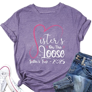 Flat lay of purple cotton T-shirt with Sisters On The Loose print and 2025 slogan