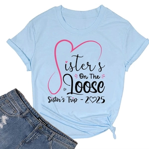 Flat lay detail of a light blue T-shirt with Sisters On The Loose 2025 graphic print