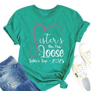Detail of mint green Sisters Trip 2025 t-shirt with knotted hem and stylish graphic print