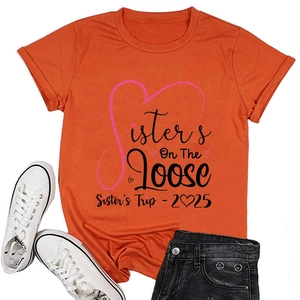 Flat lay of orange Sisters On The Loose t-shirt with black shorts and white sneakers