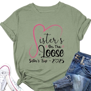 Flat lay of light green Sisters On The Loose 2025 t-shirt with jeans and white shoes