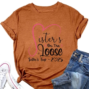 Flat lay detail of Sisters On The Loose 2025 print on a caramel crew neck T-shirt