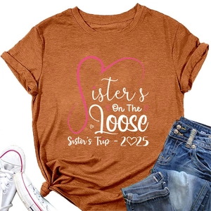 Flat lay of caramel orange t-shirt with Sisters On The Loose print and denim shorts