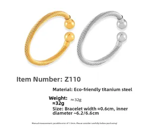 Detail of twisted cable cuff bracelets in gold and silver finish with ball ends