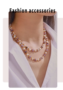 Détail d'un collier double épaisseur avec cristal violet, perle et billes dorées