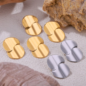 Minimalist teardrop 18k gold and silver titanium steel earrings in a natural setting