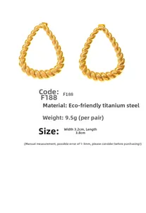 Macro view of gold teardrop earrings with spiral texture made of titanium steel