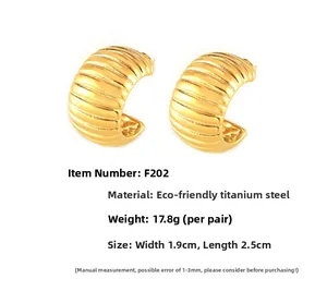 Detail view of gold titanium steel hoop earrings with textured vertical ridges