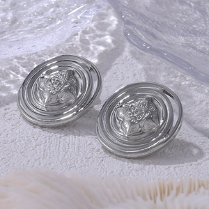 Vintage silver-plated round coin stud earrings with embossed design on textured background