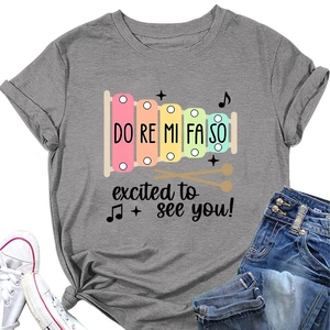 Détail du t-shirt gris à col rond avec imprimé xylophone coloré et motifs musicaux