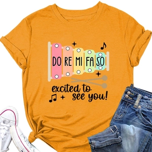 Détail du t-shirt jaune à col rond avec imprimé xylophone arc-en-ciel et notes