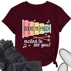 Détail d'un t-shirt bordeaux à col rond avec motif xylophone et nœud à l'ourlet