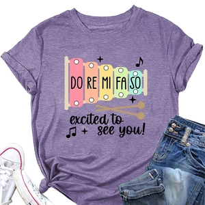 Détail d'un t-shirt violet à col rond avec motif xylophone et citation en anglais