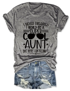 Flat lay of heather grey T-shirt with 'Super Cool Aunt' slogan and distressed denim shorts