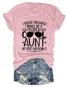 Flat lay of pink cotton T-shirt with 'Super Cool Aunt' slogan and distressed denim shorts