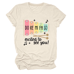 Détail du t-shirt en coton beige avec imprimé xylophone coloré et texte de gamme musicale