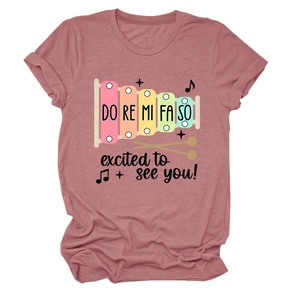 Détail d'un t-shirt rose poudré à col rond avec motif de xylophone et texte