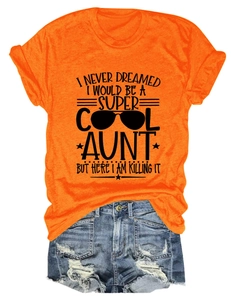 Flat lay of women's orange crew neck t-shirt with sunglasses graphic and denim shorts