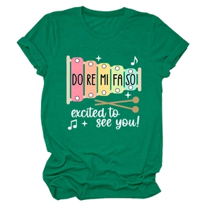 Détail du t-shirt vert foncé avec imprimé xylophone arc-en-ciel et motifs de musique