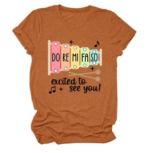 Gros plan d'un T-shirt caramel avec motif xylophone arc-en-ciel et texture de tissu fine