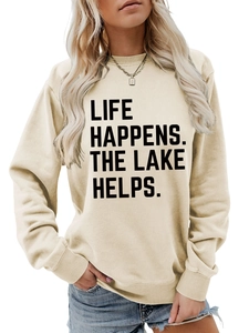 Close-up of Life Happens The Lake Helps slogan print on a cream crewneck sweatshirt