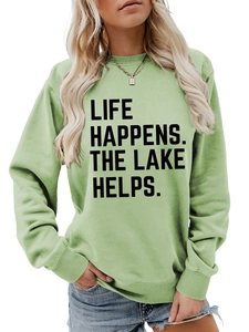 Detail of sage green sweatshirt featuring black Life Happens The Lake Helps lettering